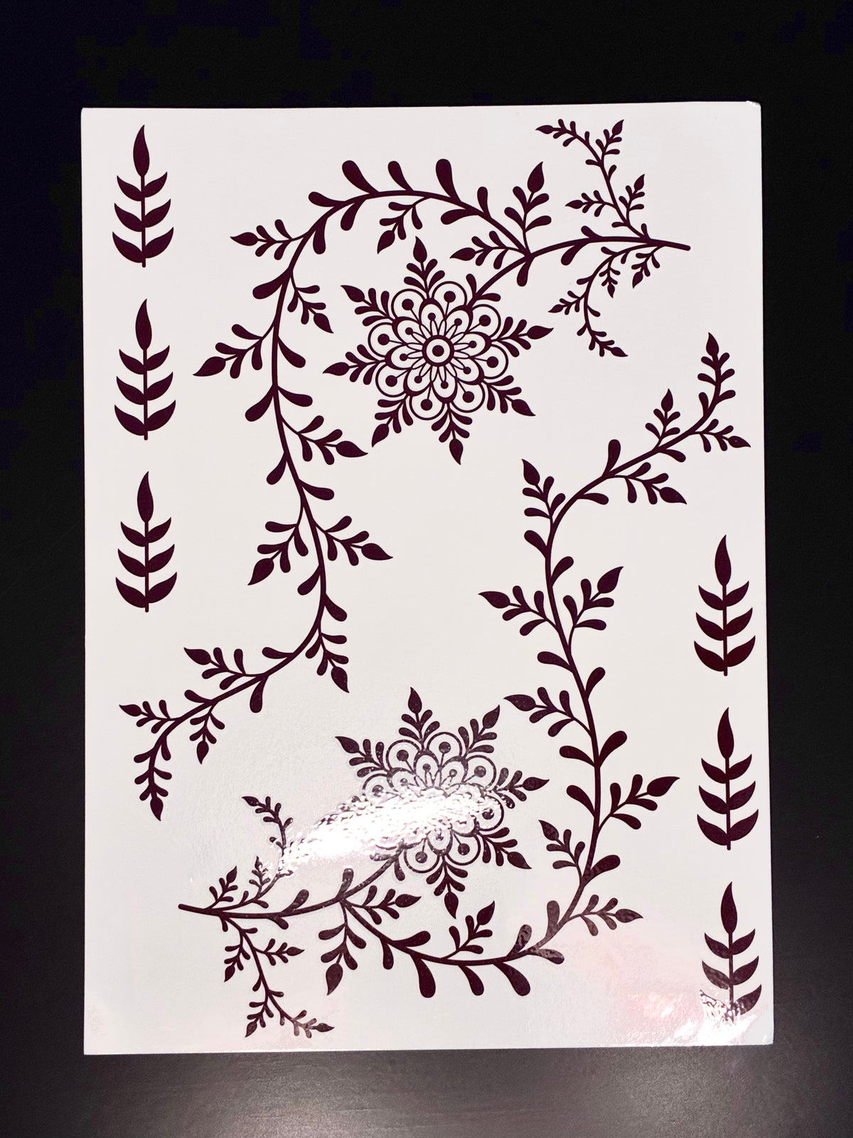 Red full-hand henna transfer sheet featuring floral vines, leafy accents, and traditional mehndi-inspired artwork.