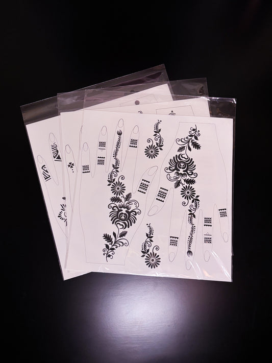 A fanned-out stack of temporary tattoo or henna stencil sheets packaged in clear plastic sleeves, displaying black floral and geometric patterns designed to fit the shape of a hand and fingers.