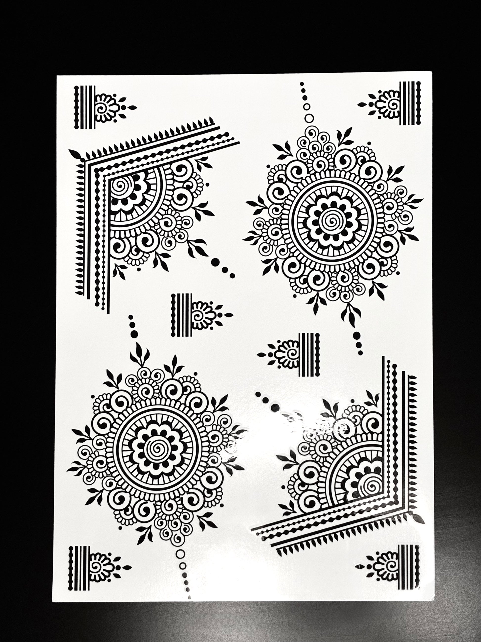 Black mandala henna transfer sheet with intricate circular mehndi designs and decorative corner patterns.