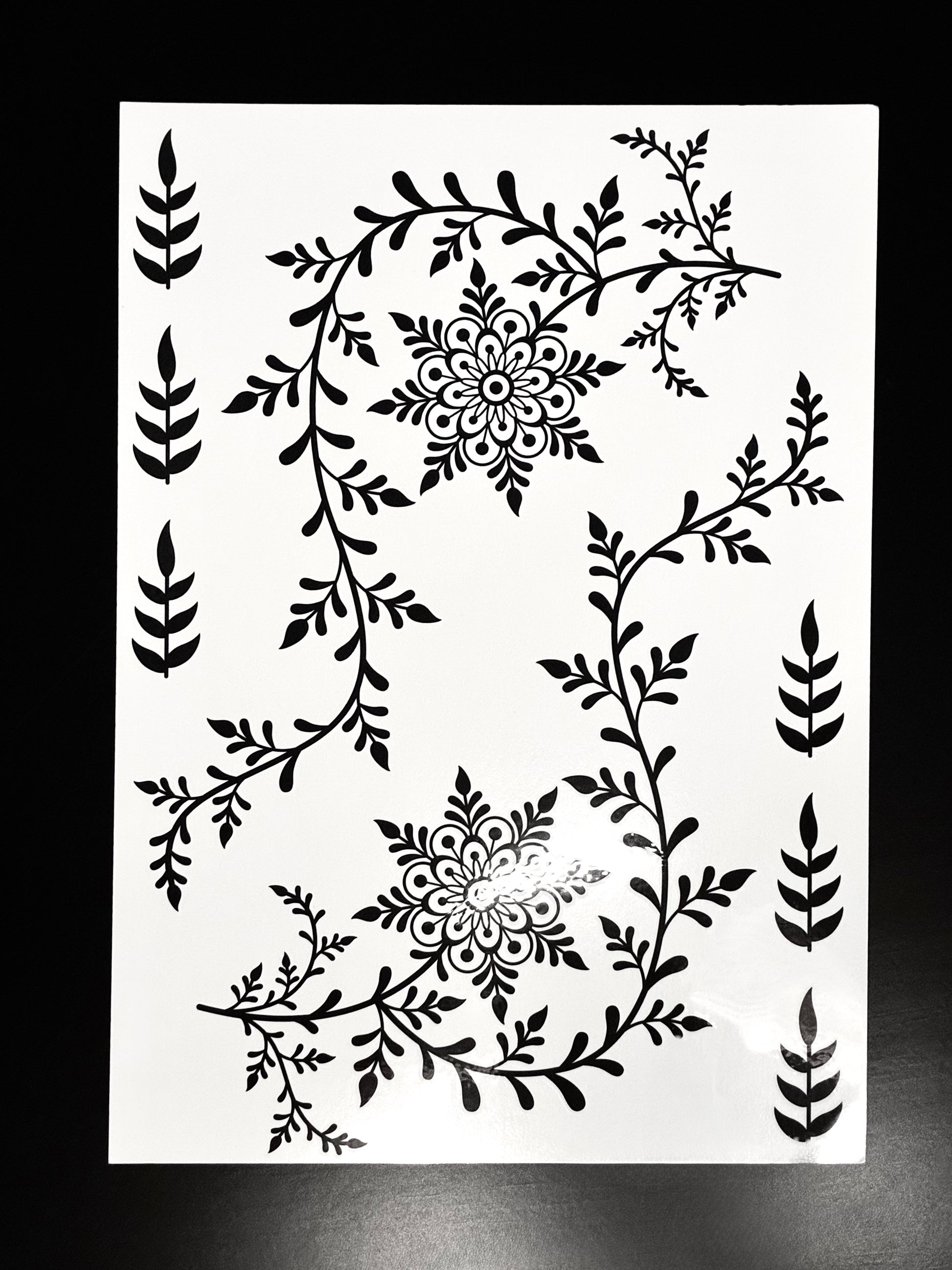 Black full-hand henna transfer sheet featuring floral vines, leafy accents, and traditional mehndi-inspired artwork.