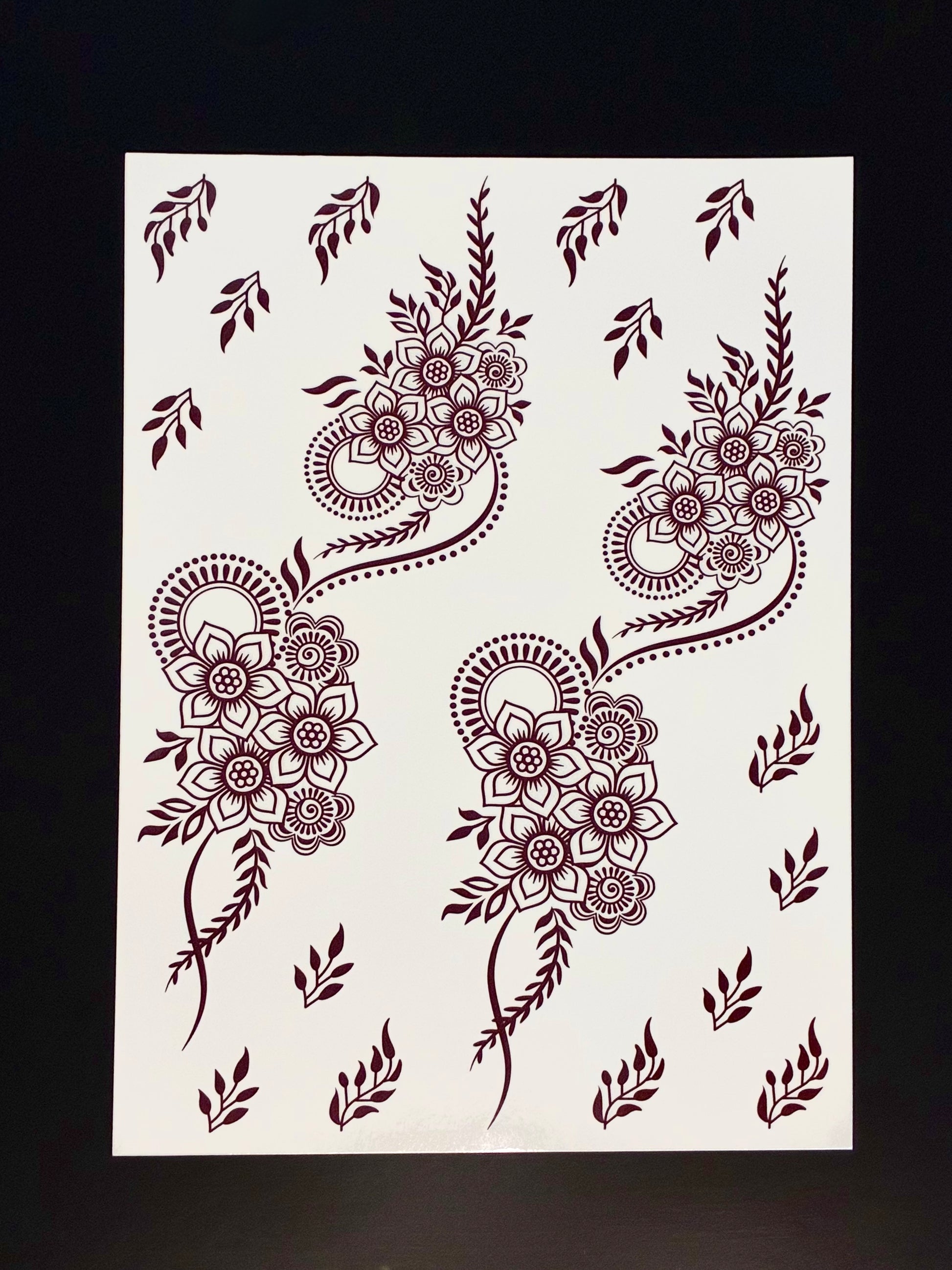 Red paisley henna transfer sheet with floral motifs, detailed mehndi patterns, and decorative filler elements.